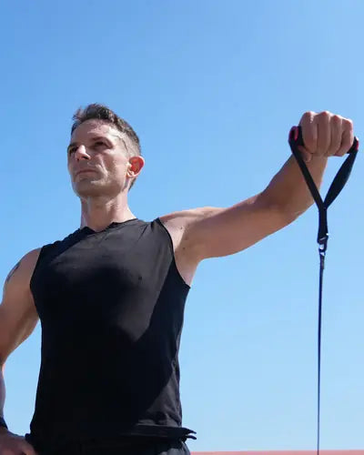 Standing cable raise outdoors under a blue sky
