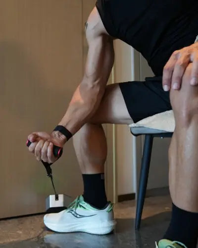Seated single-arm curl with Go-Tone anchored on the floor at home